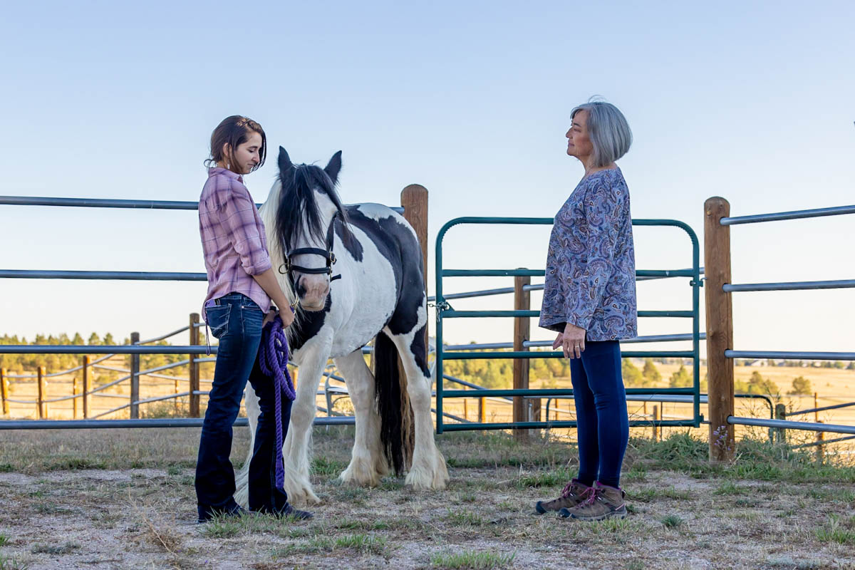 Lizette with a paint horse at a fence